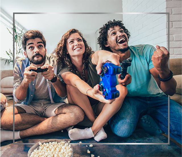 Skupina nasmiješenih mladih ljudi sjedi na podu i igra videoigre, sretni su nakon liječenja gljivične infekcije kože Canestenom